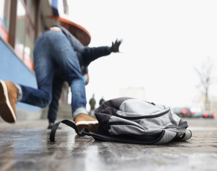 Person slipping and falling on a slippery pavement